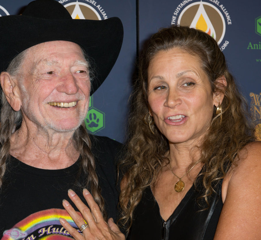 Annie & Willie Nelson standing together with a blue background featuring logos.